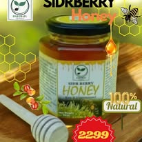 Jar of honey with a spoon and label on a white background