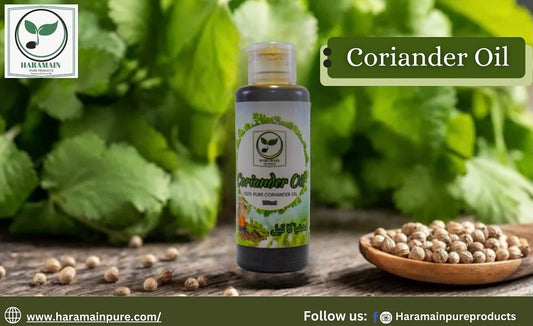 Bottle of coriander oil with coriander seeds and leaves on a wooden surface, featuring the Haramain Pure logo.