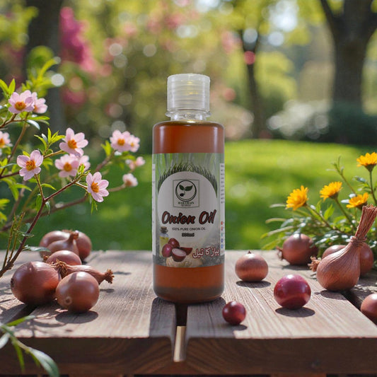 Bottle of onion oil on a wooden table with onions and flowers in a garden setting