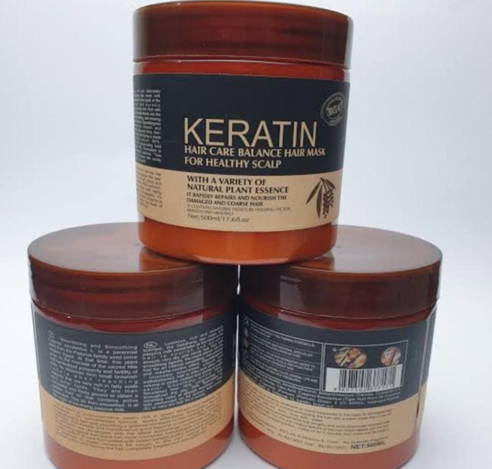 Three jars of Keratin hair care product stacked on a white background