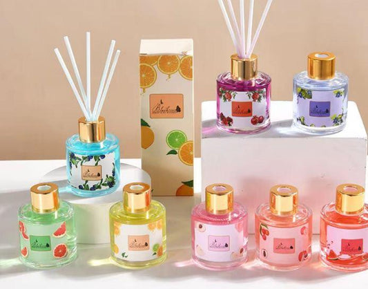 Collection of small bottles with colorful labels and gold caps on a beige background