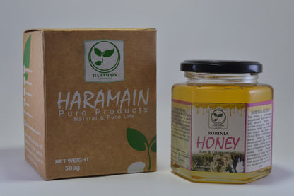 Jar of honey and box of Haramain Pure Products on a white background