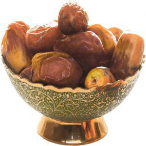 Bowl of dates with a decorative pattern on a white background